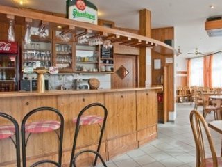 Dřevěný barový pult restaurace V Oblouku s výčepem a sklenicemi