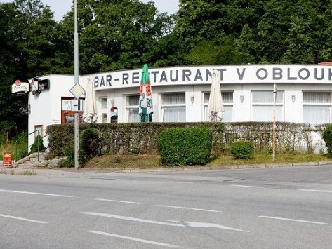 Budova restaurace V Oblouku s nápisem Bar-Restaurant při pohledu od hlavní silnice