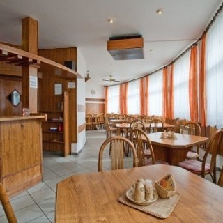 Vnitřní sál restaurace s dřevěným barem a stoly